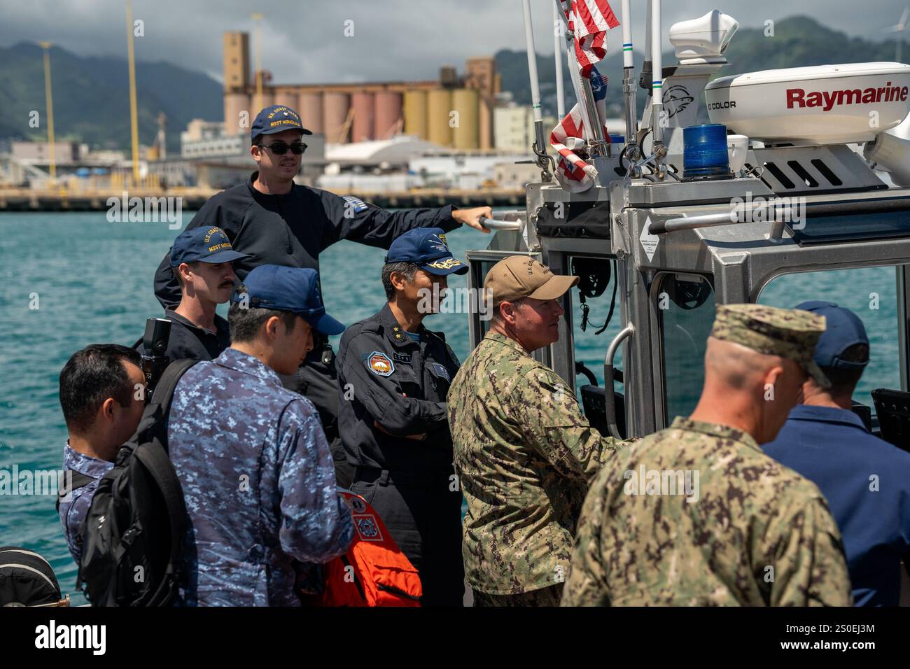 Japan Maritime Self-Defense Force (Japan Maritime Self-Defense Force) Hinterer ADM. Kazushi Yokota, Kommandeur, Escort Flotilla 3 und Exercise Rim of the Pacific (RIMPAC) 2024 kombinierte Task Force Vize Commander und Cdr. Patrick Hanley, Commanding Officer, Port Security Unit 311, diskutiert und demonstriert Fähigkeiten auf der Küstenwache-Basis Honolulu, Hawaii, 25. Juli. RIMPAC ist die weltweit größte internationale maritime Übung mit über 25.000 Teilnehmern aus 29 verschiedenen Ländern, die kooperative Beziehungen zur Gewährleistung der Sicherheit auf See fördern. Die Übung 2024 ist das erste Jahr, in dem PSUs seit Beginn des RIMPAC teilgenommen haben Stockfoto