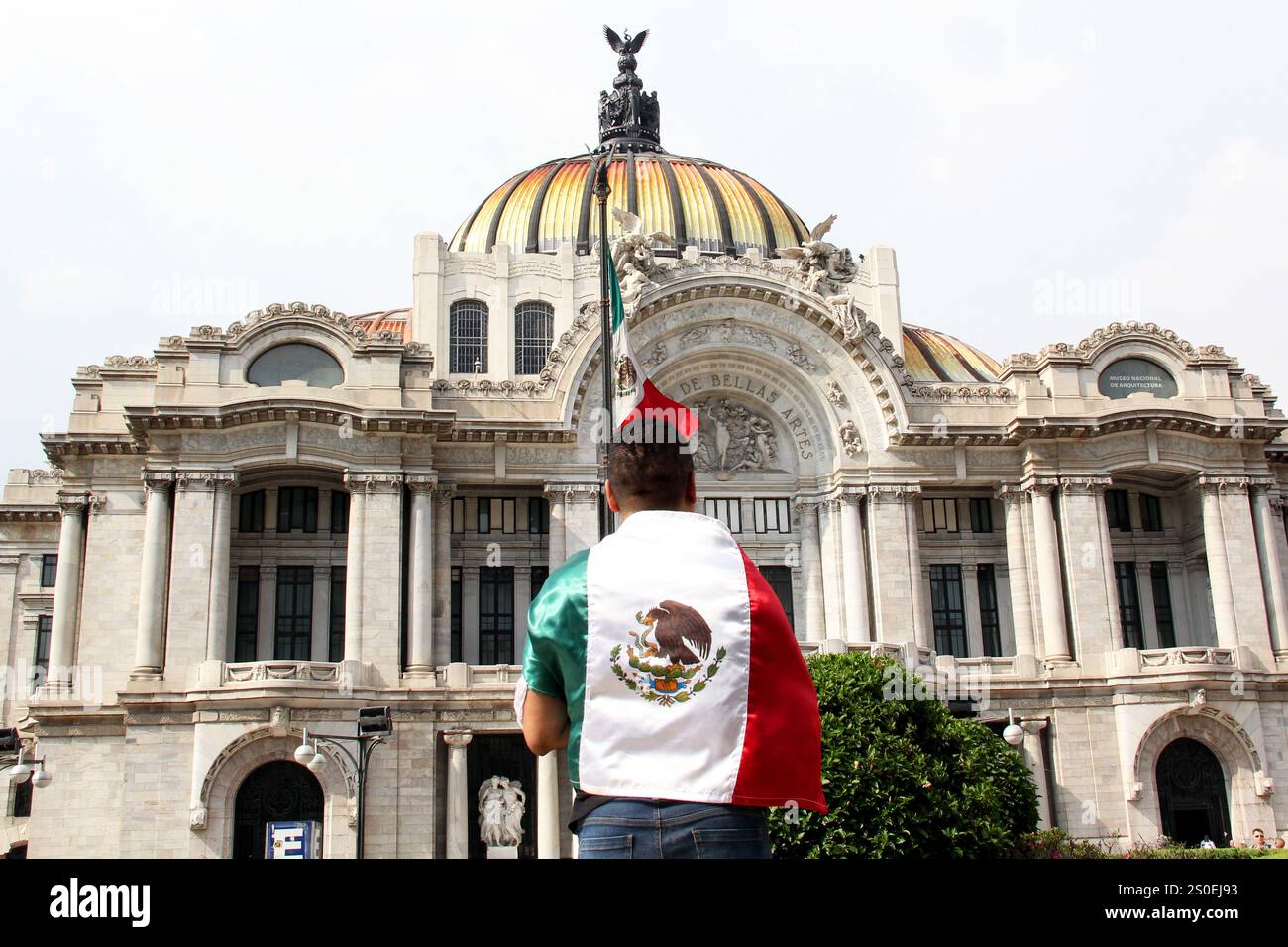 Mexiko-Stadt, Mexiko - 6. September 2023: Der Mann hält die mexikanische Flagge vor dem Palacio de Bellas Artes, um die Nationalfeiertage zu feiern Stockfoto