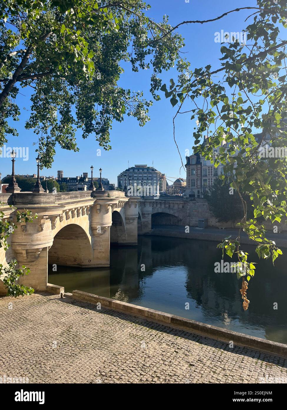 Die wunderschöne Pont Neuf Brücke in Paris auf einem frühen Morgenspaziergang, während die Stadt aufwacht. Ruhe und Schönheit verbinden sich an einem Sommermorgen - Smartphone-aufgenommenes Stockfoto