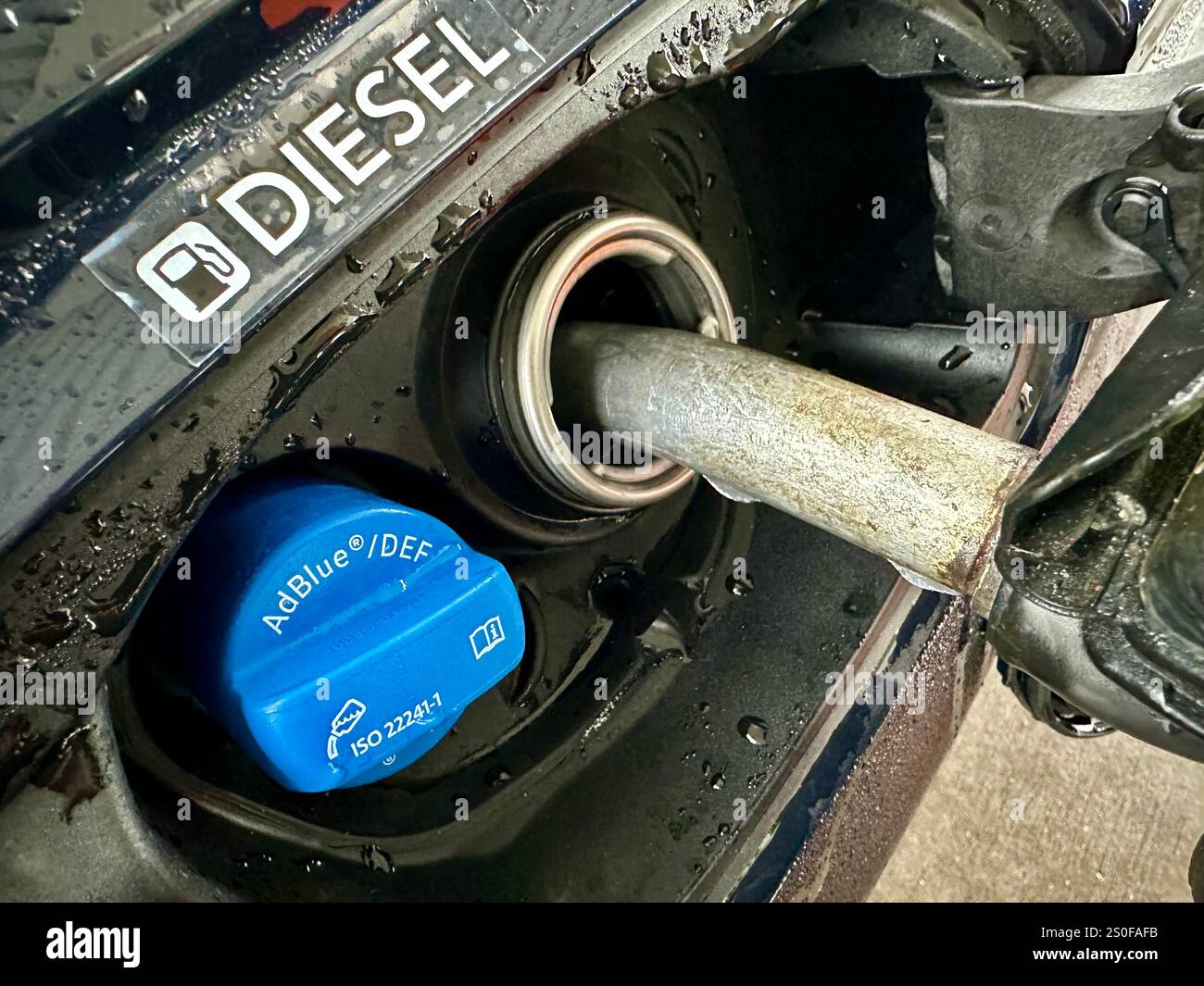 Betanken eines Autos mit Diesel, Nahaufnahme der Feeling Pistole mit einem Schild über dem Stockfoto