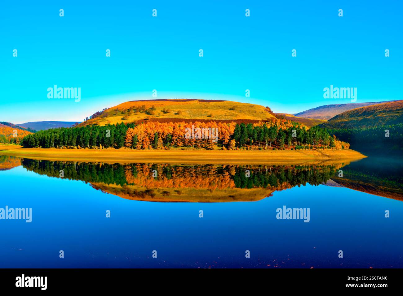 Blick auf die Reflexionen auf dem noch blauen Wasser des Lake Derwent im Peak District an einem sonnigen wolkenfreien Tag. Stockfoto