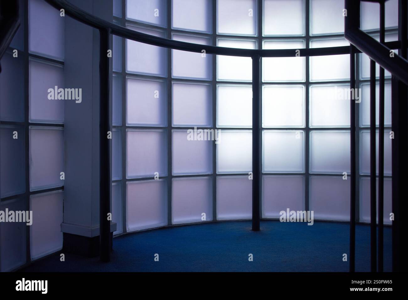 Niedriger Blick auf den Innenkorridor mit opaken Glasblöcken und bannister Stockfoto
