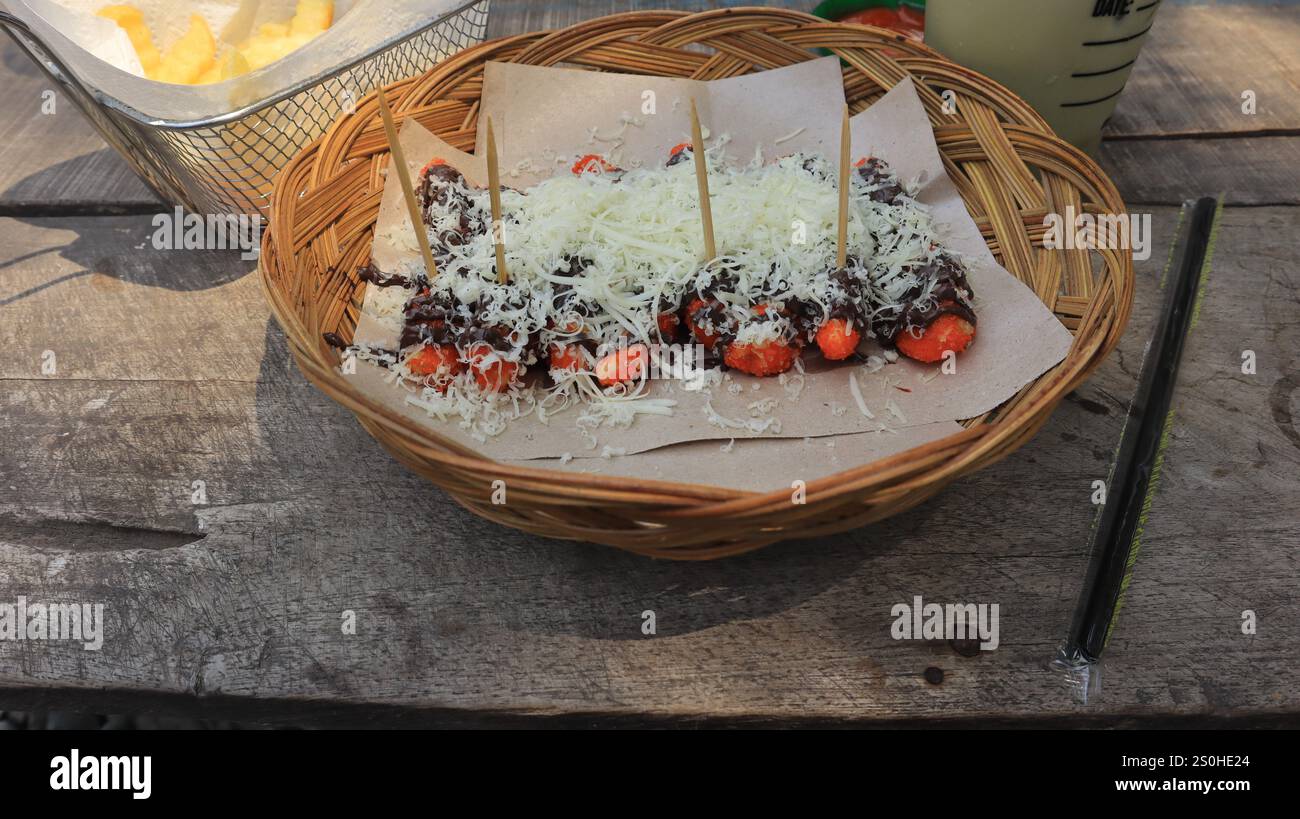 Auf dem Tisch werden Snacks serviert, Kartoffeln und gebratene Bananen mit Käse bestreut Stockfoto