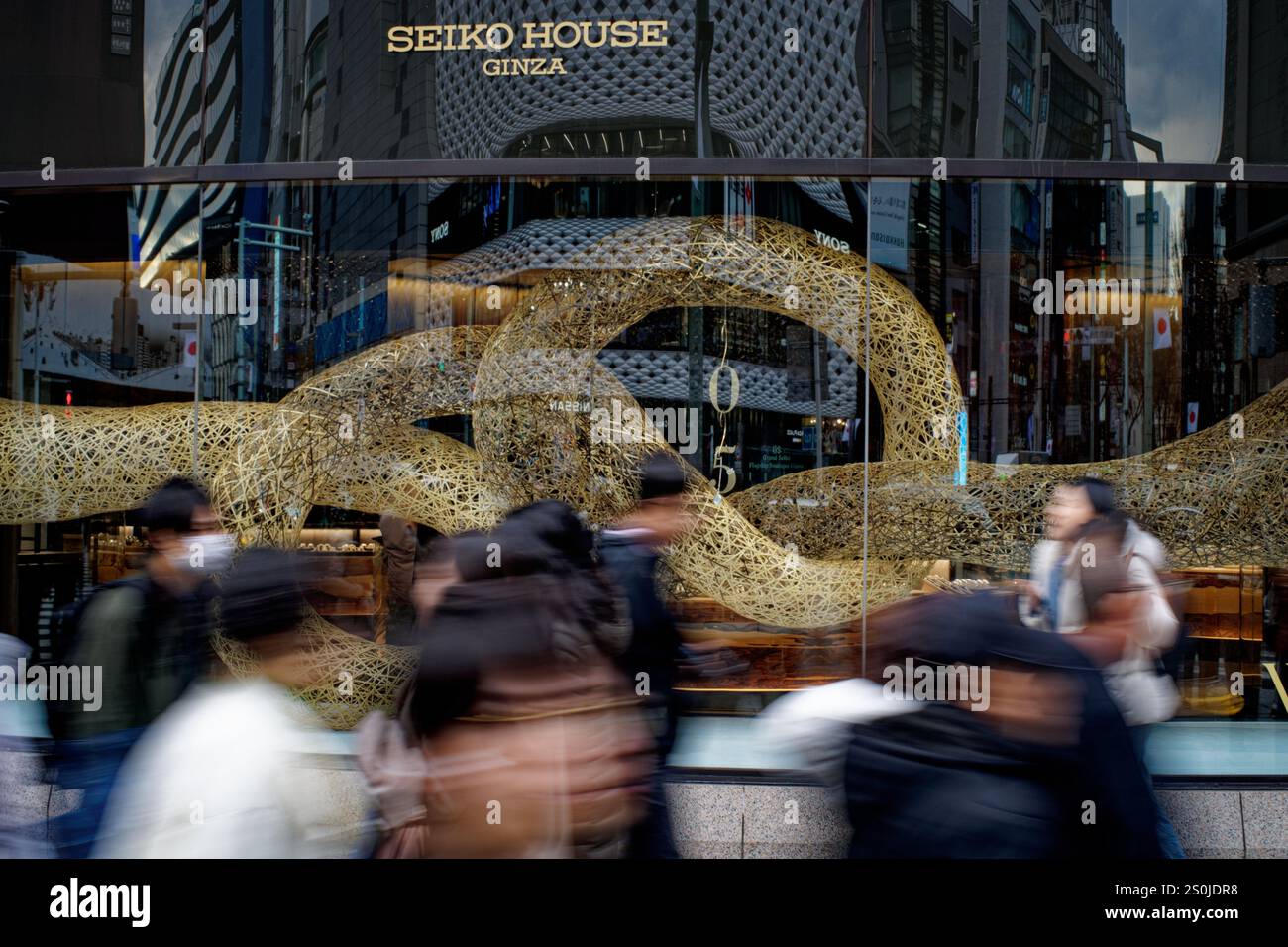Tokio, Japan. Dezember 2024. Die Leute laufen an einer Schlangenförmigen Kunstinstallation in Tokio, Japan, am 27. Dezember 2024 vorbei. Das Jahr 2025 ist das Schlangenjahr in Japan. Quelle: Zhang Xiaoyu/Xinhua/Alamy Live News Stockfoto