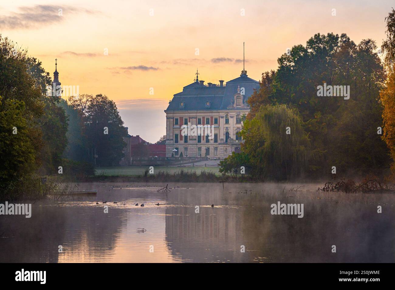 Majestätisches Schloss Pszczyna über dem Nebelsee bei Sonnenaufgang - bezaubernde Morgenszene Stockfoto