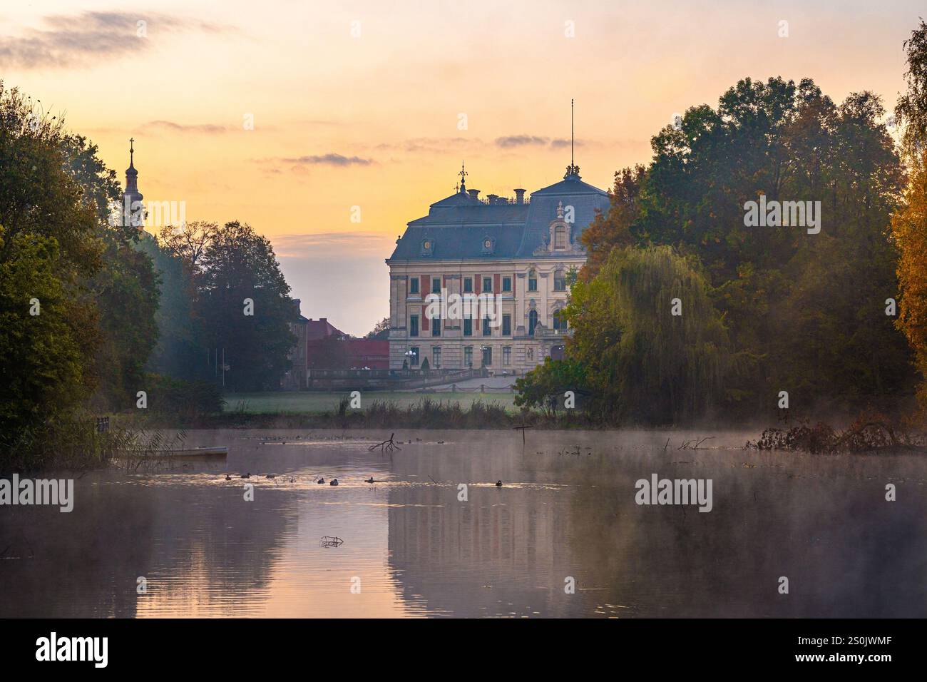 Majestätisches Schloss Pszczyna über dem Nebelsee bei Sonnenaufgang - bezaubernde Morgenszene Stockfoto