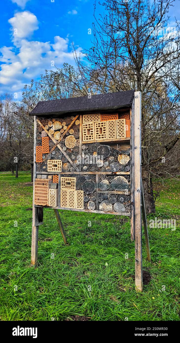 Ein Insektenhotel oder -Haus in einem Garten in Meersburg, Deutschland, mit einem Fliesendach als Regenschutz. Lebensraum für kleine Insekten Stockfoto