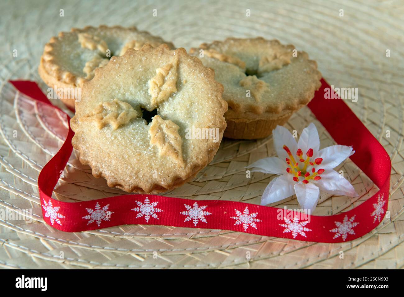 Drei Hackkuchen mit rotem und weißem Schneeflockenband zu Weihnachten Stockfoto