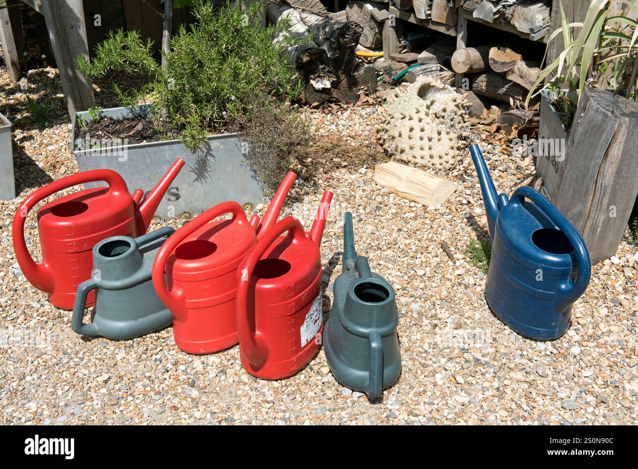 Fünf Plastikdosen stehen auf Kies, der Skip Garden, Kings Cross, London Borough of Camden. Stockfoto