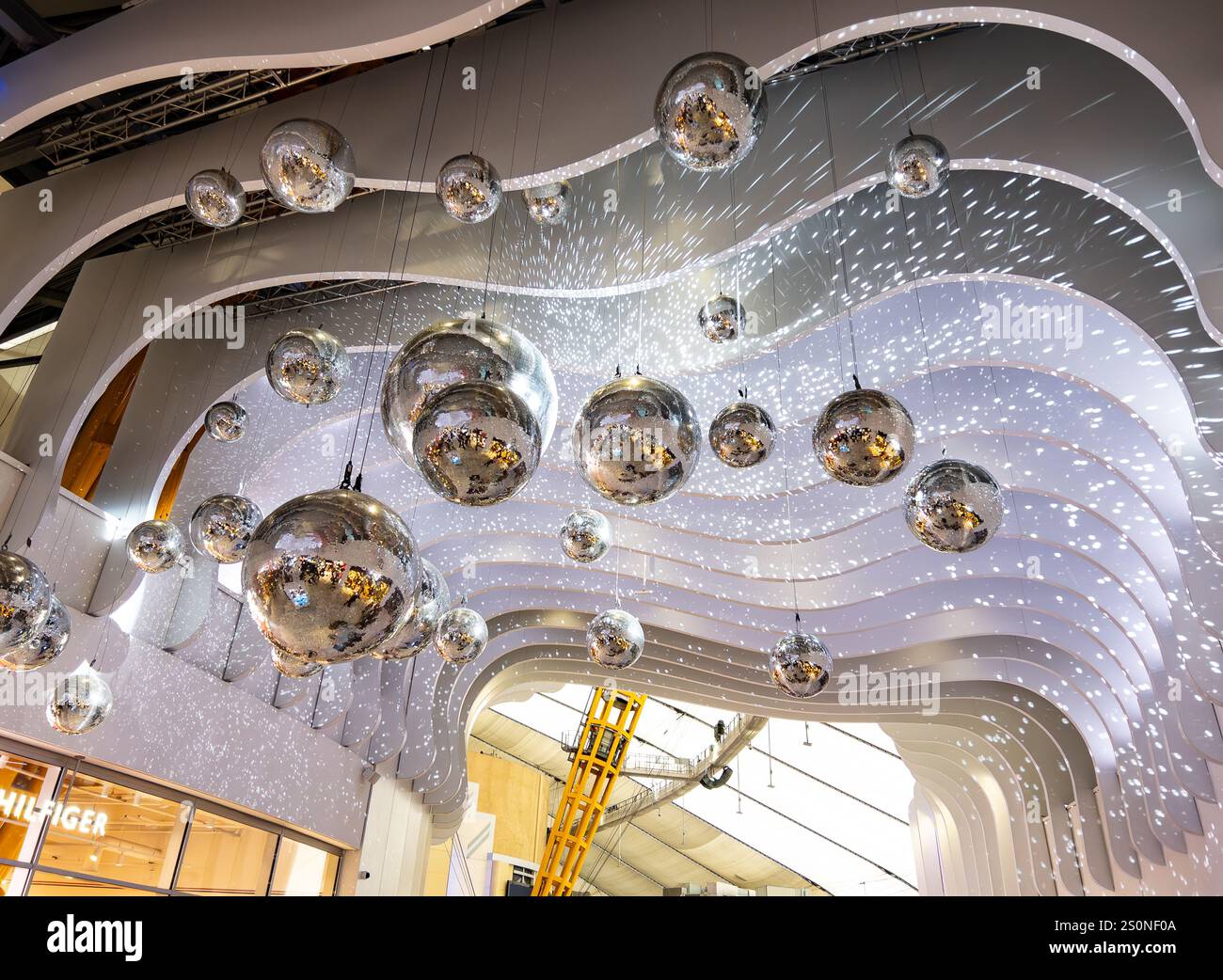 Futuristisches Innendesign mit reflektierenden Silberkugeln und wellenförmigen weißen Decken mit Lichteffekten in einem modernen Gebäude, der O2 Arena - Smartphone-aufgenommenes Stockfoto