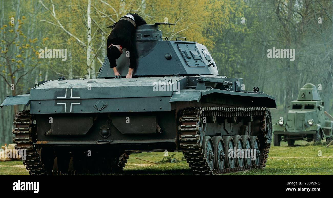 Nach Der Schlacht. Als tote deutsche Panzerbesatzung verkleidet liegt der Nachenakteur auf dem leichten Panzerpanzer der Wehrmacht bei der Rekonstruktion der Schlachten des Zweiten Weltkriegs getötet Stockfoto