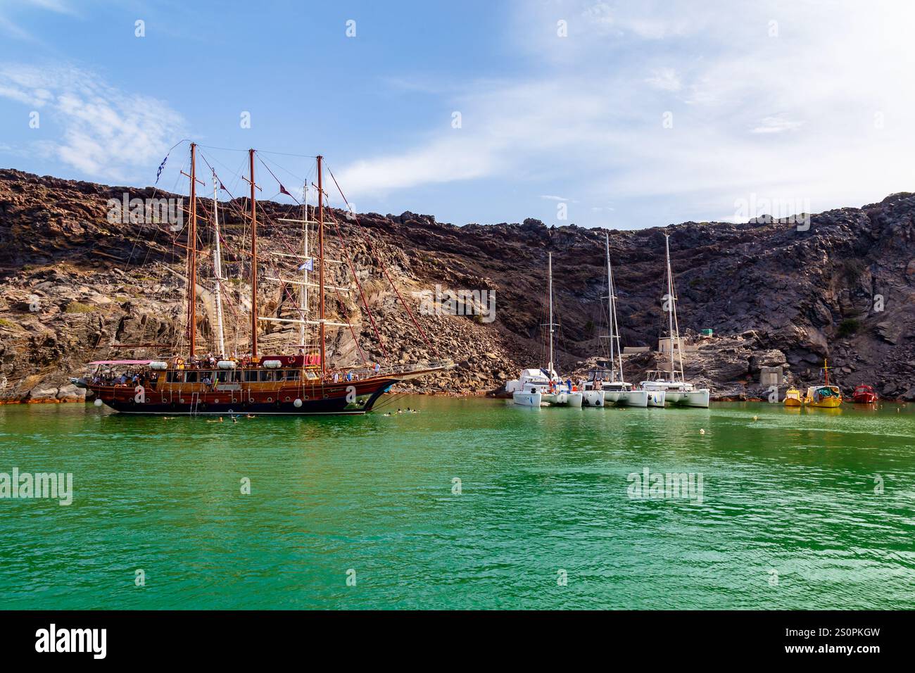 Malerischer Hafen mit Segelschiffen und Katamaranen, umgeben von Rocky Coastal Cliffs Stockfoto