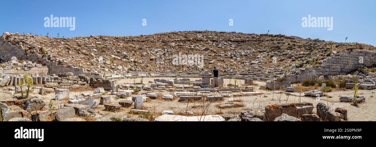Ruinen eines antiken Amphitheaters umgeben von natürlichen Hügeln unter klarem Himmel, Delos, Griechenland Stockfoto