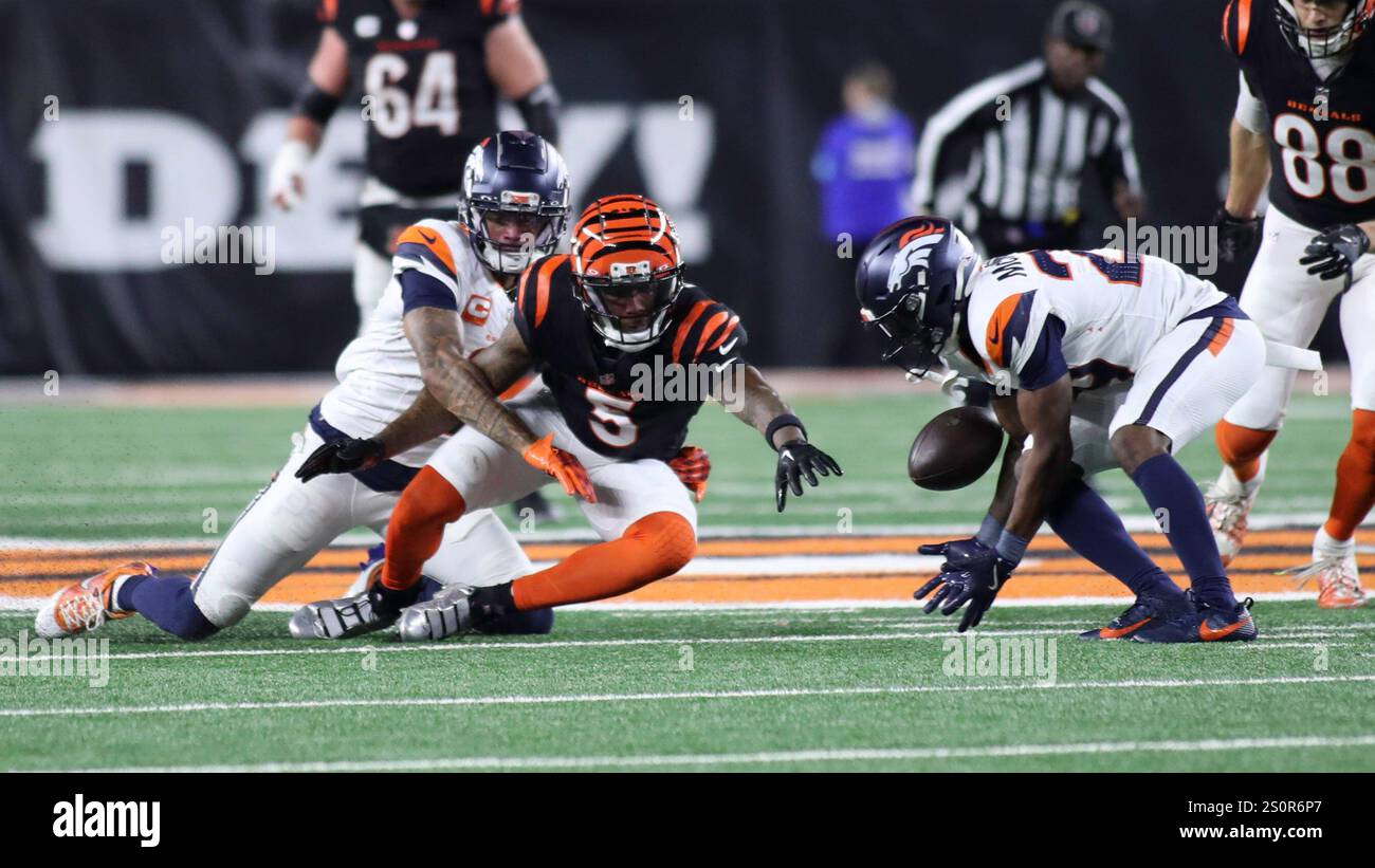 Cincinnati, Ohio, USA. Dezember 2024. Cincinnati Bengals WR Tee Higgins (5) fummelt den Ball und Denvers Ja'Quan McMillian (rechts) versucht, ihn in der 17. WOCHE der NFL reguläre Saison zwischen den Cincinnati Bengals und den Denver Broncos in Cincinnati, Ohio, zurückzugewinnen. Kevin Schultz/CSM/Alamy Live News Stockfoto