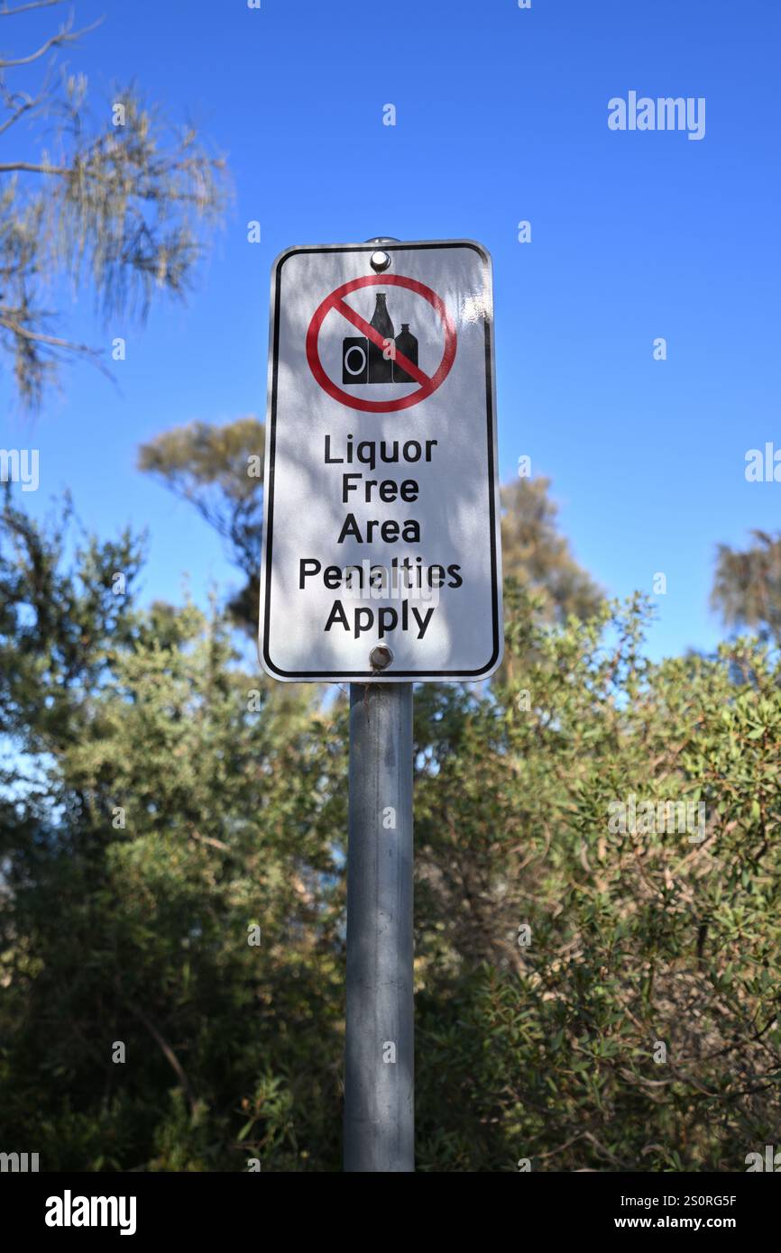 Rote, weiße und schwarze Zeichen warnen, dass es sich um einen alkoholfreien Bereich handelt und dass Sanktionen für diejenigen gelten, die Alkohol trinken Stockfoto