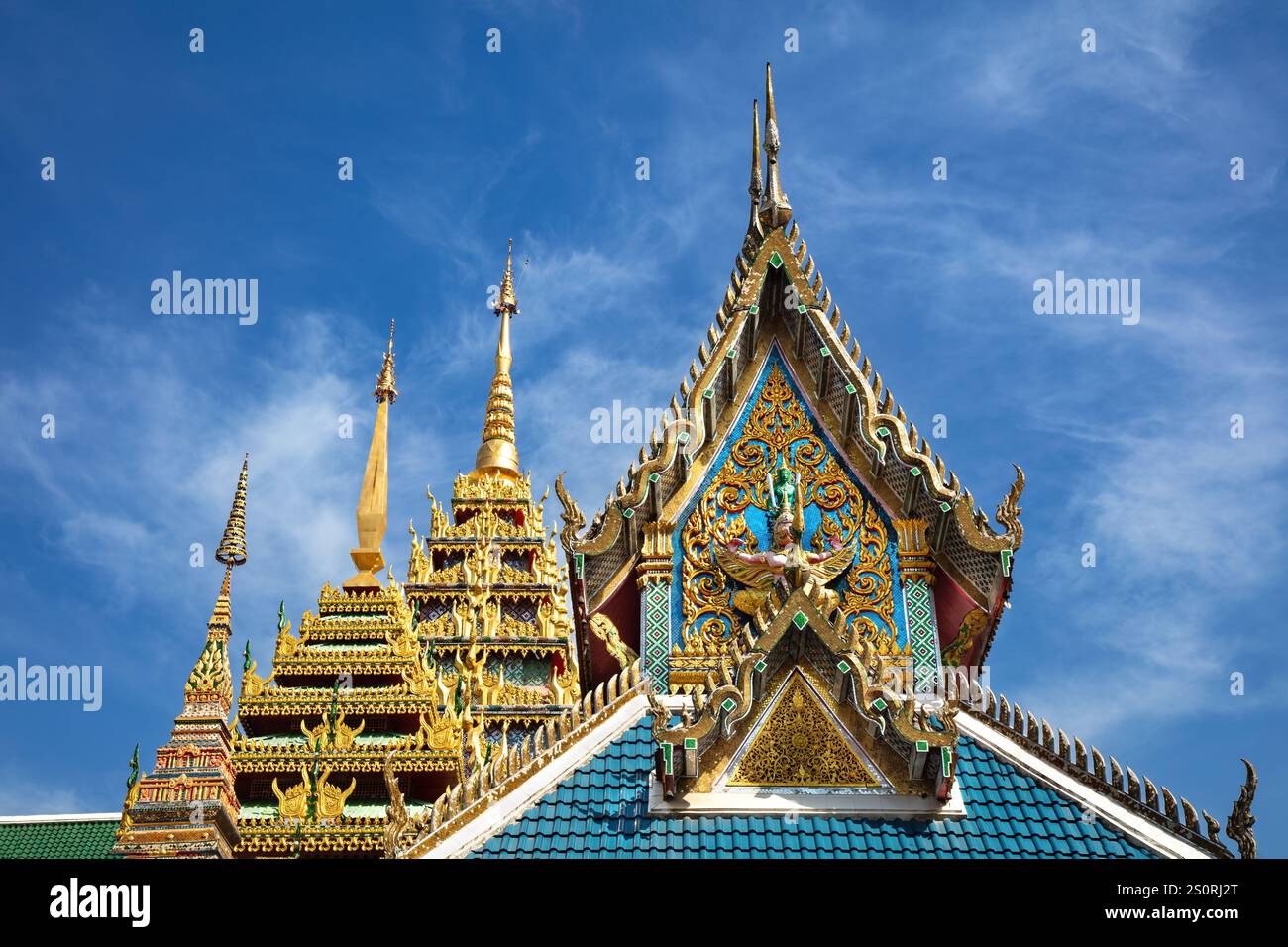 Dekorative Fassade und Dächer im buddhistischen Tempel von Wat Khun Chan, Bangkok, Thailand. Blauer Himmel und Wolken im Hintergrund. Stockfoto