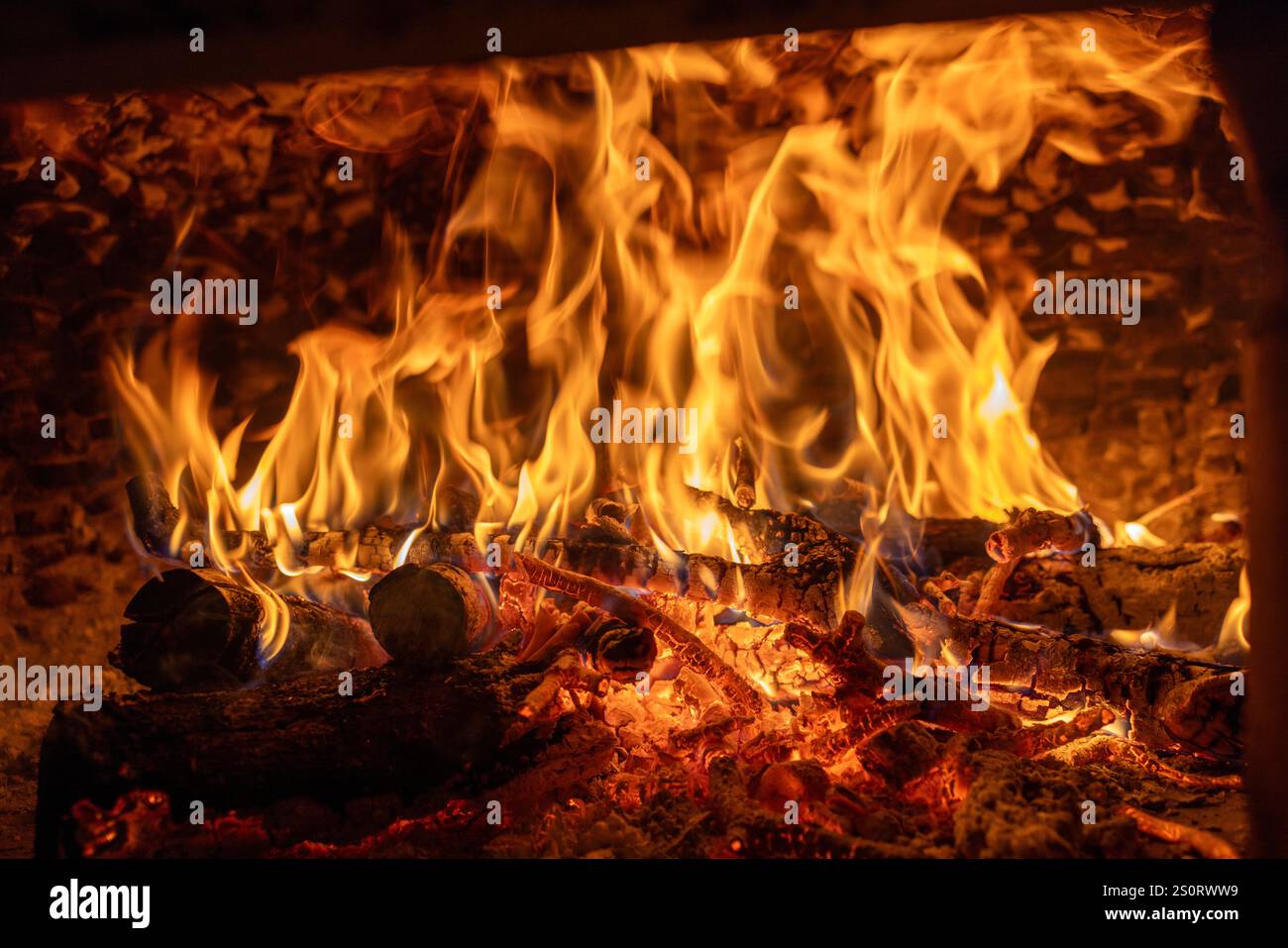 Nahaufnahme intensiver Flammen in einem traditionellen Holzofen mit brennenden Stämmen und glühender Glut. Diese feurige Szene weckt Wärme, Energie. Stockfoto Nahaufnahme intensiver Flammen in einem traditionellen Holzofen mit brennenden Stämmen und glühender Glut. Diese feurige Szene weckt Wärme, Energie. Stockfoto