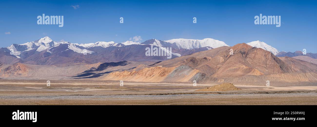 Farbenfrohes Landschaftspanorama mit schneebedeckten Bergen auf dem Pamir Highway in hoher Höhe zwischen Karakul und Kyzyl Art, Gorno-Badakhshan, Tadschikistan Stockfoto