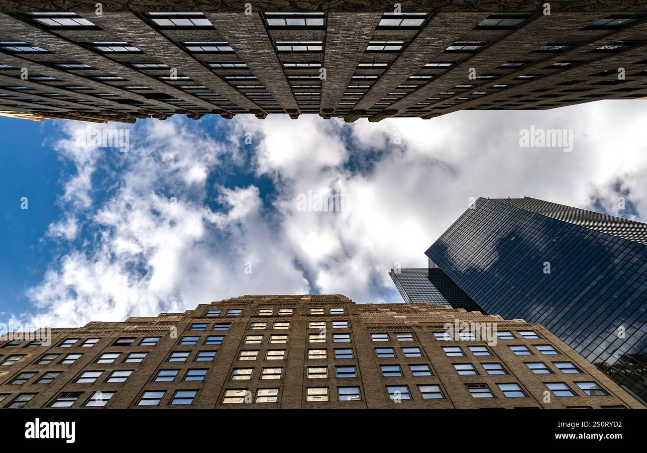 Ein flacher Blick auf hohe Gebäude vor bewölktem Himmel mit architektonischen Details und kontrastierenden Stilen. Stockfoto