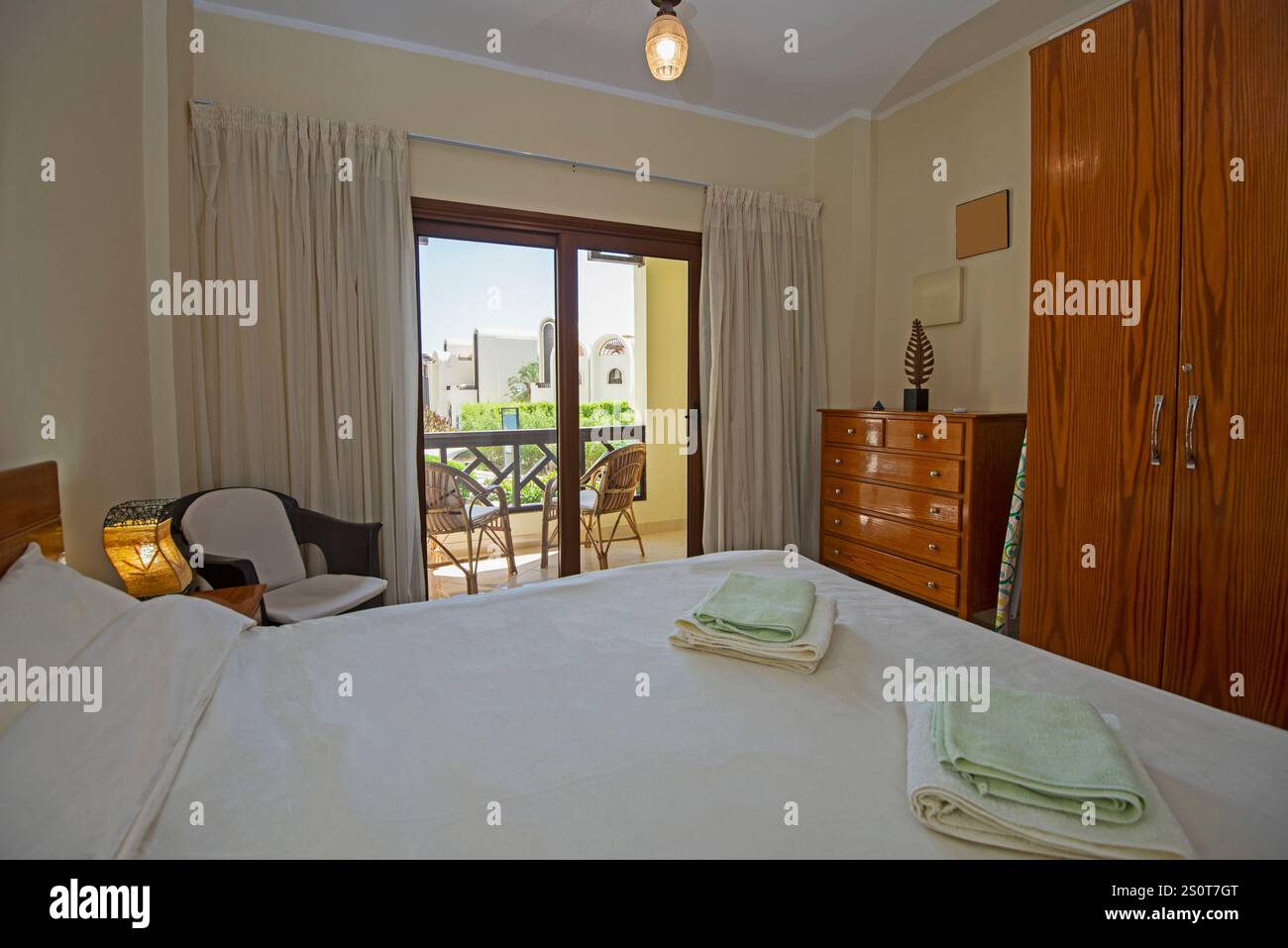 Inneneinrichtung Einrichtung Einrichtung von luxuriösem Schauzimmer mit Möbeln und Doppelbett mit Kleiderschrank und Balkon Stockfoto