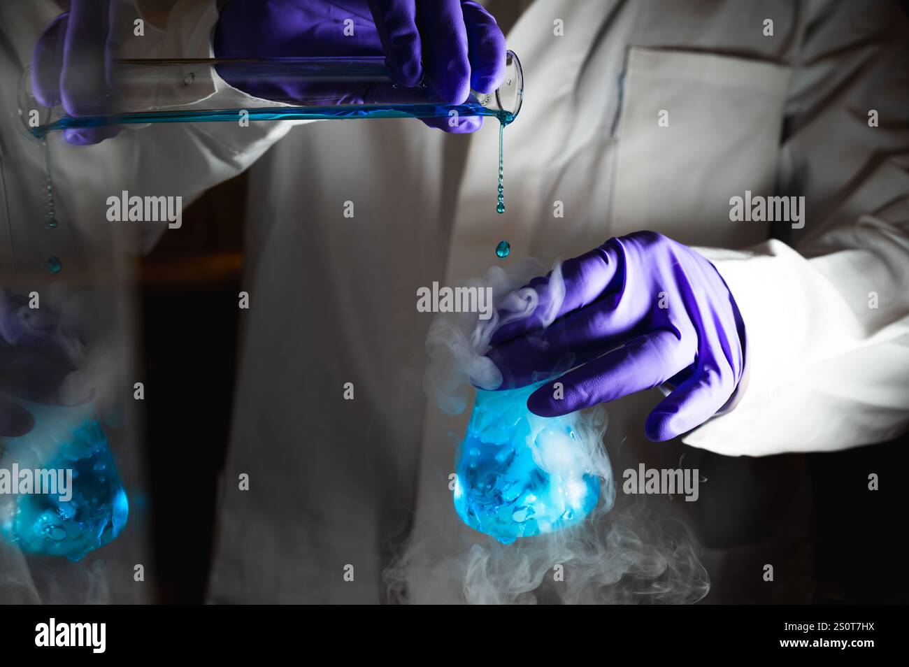 Rauchige Experimente mit blauer Farblösung. Wissenschaftler arbeiten an chemischen Reaktionen und erzeugen dicken Rauch aus einem Glaskolben. Kopierraum Stockfoto