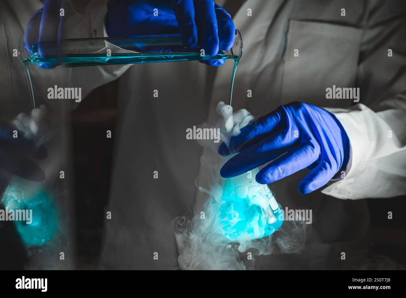 Rauchige Experimente mit blauer Farblösung. Wissenschaftler arbeiten an chemischen Reaktionen und erzeugen dicken Rauch aus einem Glaskolben. Kopierraum Stockfoto