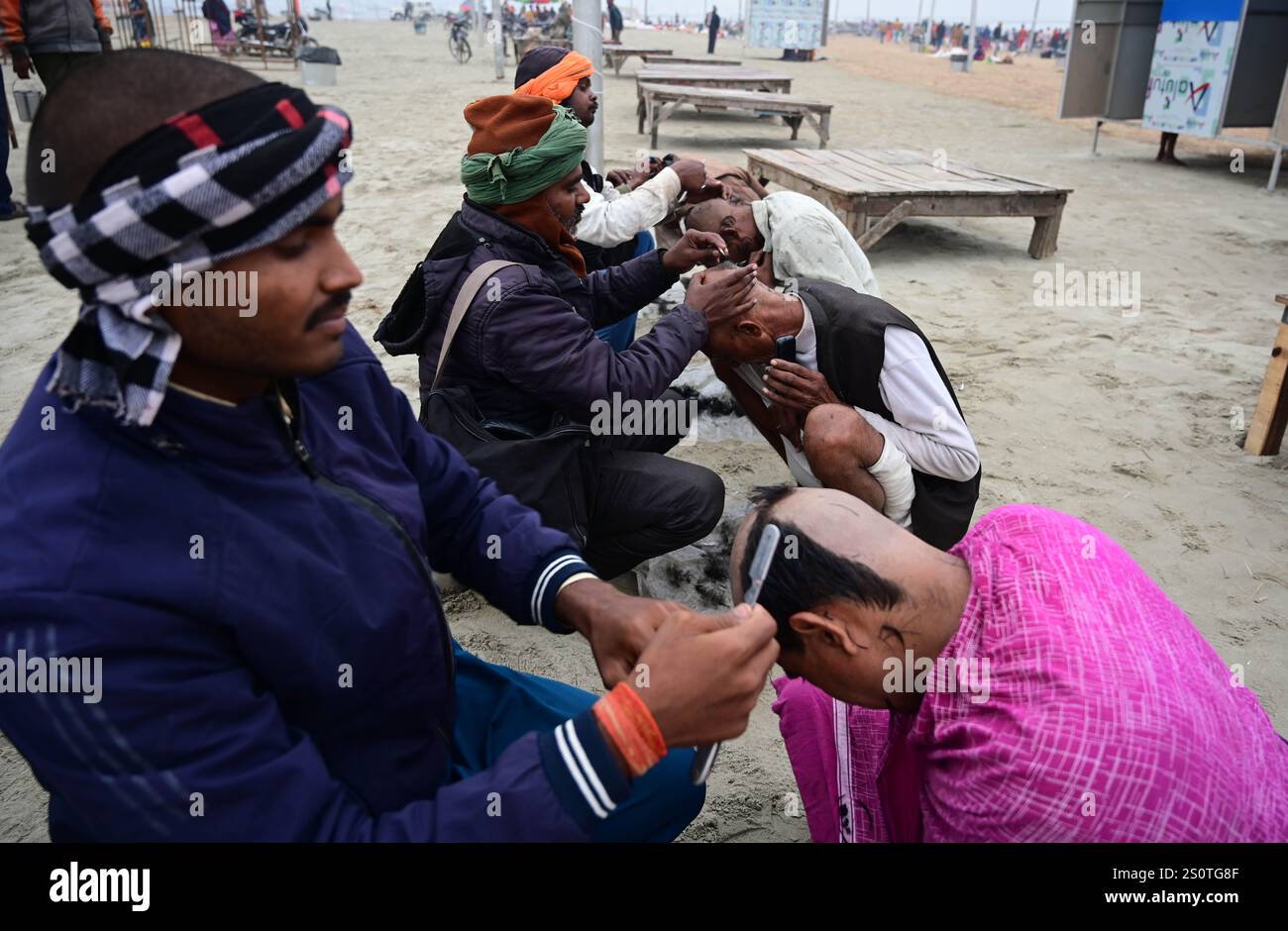 Prayagraj, Indien. Dezember 2024. Prayagraj: Friseure rasieren Devotee-Kopf für Rituale in Sangam Ahead Maha Kumbh 2025 in Prayagraj am Samstag, 28. Dezember 2024. (Foto: Prabhat Kumar Verma/Pacific Press) Credit: Pacific Press Media Production Corp./Alamy Live News Stockfoto