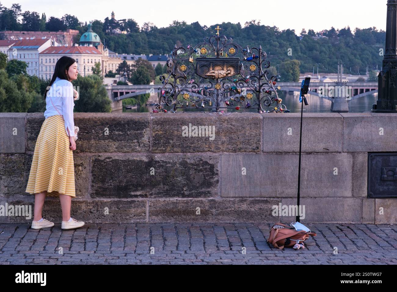 Touristen posieren für „Bild von Plakette“, die vermutlich den Ort markieren soll, an dem der Heilige Johannes von Nepomuk in die Moldau geworfen wurde, am 20. März 1393. Prag. Stockfoto