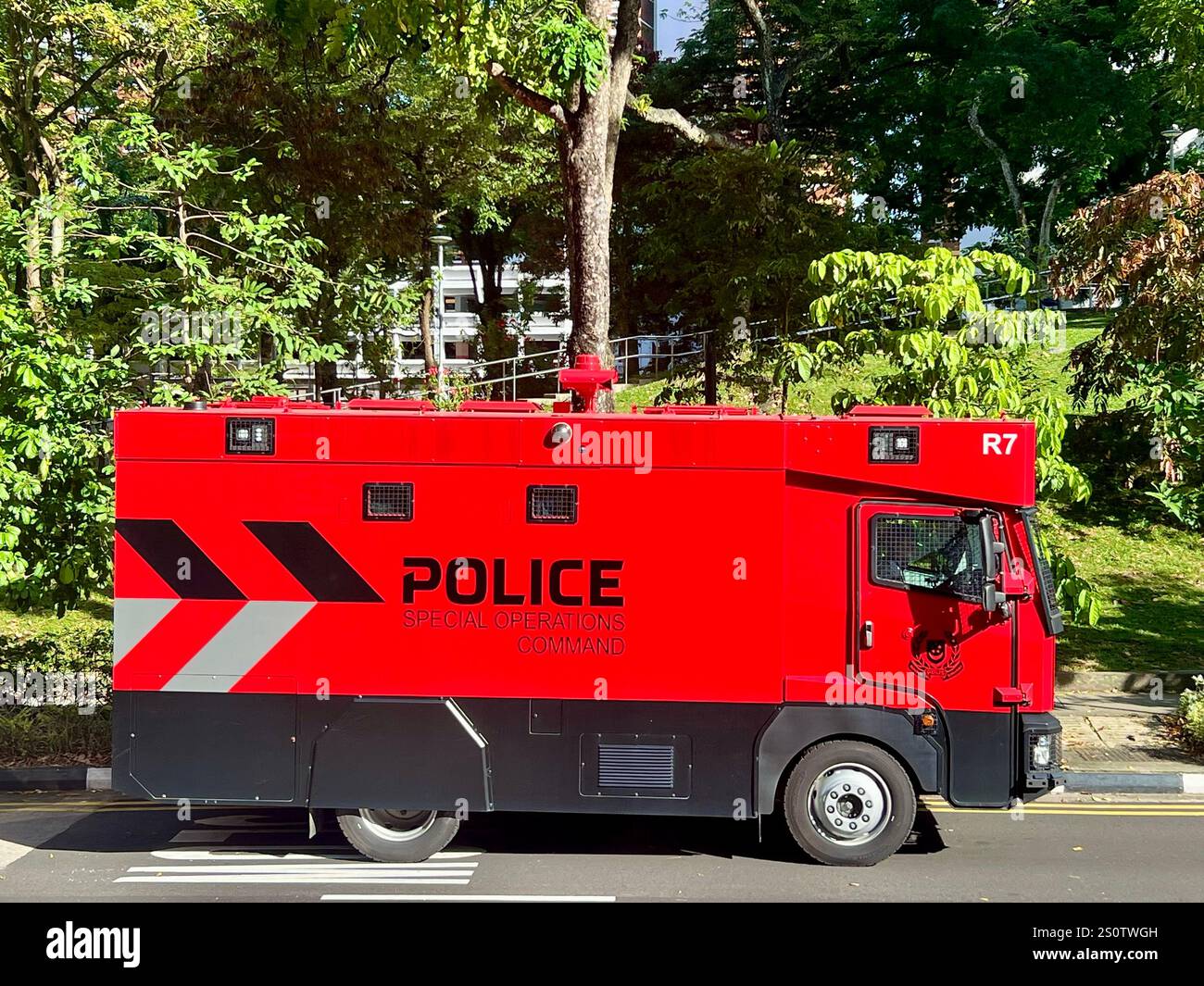 Seitenansicht des roten Fahrzeugs des Polizeikommandos zum Einsatz am Straßenrand. Eine Elite-Maschine zur Kontrolle von Aufständen. Singapur. - Smartphone-aufgenommenes Stockfoto