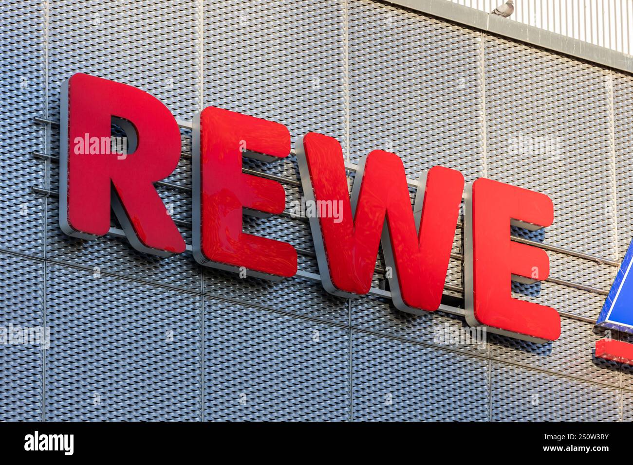 REWE-Logo-Zeichen des deutschen Supermarktes. Einzelhändler für Lebensmittel und großer Arbeitgeber. Nahaufnahme des Gebäudes außerhalb des Unternehmens. Stockfoto