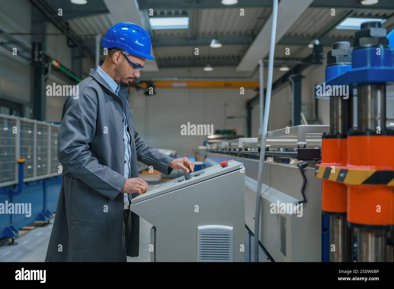 Afroamerikanischer Profi, ein Fabrikingenieur, der die industrielle Schalttafel aktualisiert. Moderne Industrie, Menschen und Automatisierungskonzepte. Stockfoto