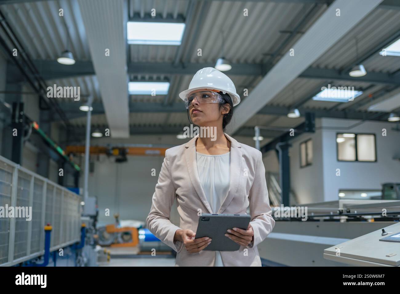 Indianerin, Betriebsleiterin, die den Produktionsprozess und die Industriemaschinen überwacht. Industrie-, Personal- und Automatisierungskonzepte. Stockfoto