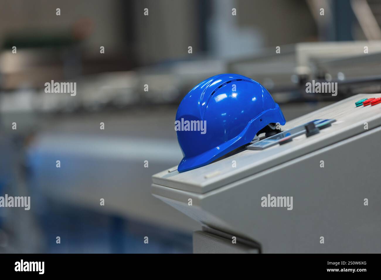 Leere Industriemaschinen in den automatisierten Produktionsanlagen mit Schutzhelm. Metallverarbeitende Industrie und Technologiekonzept. Stockfoto