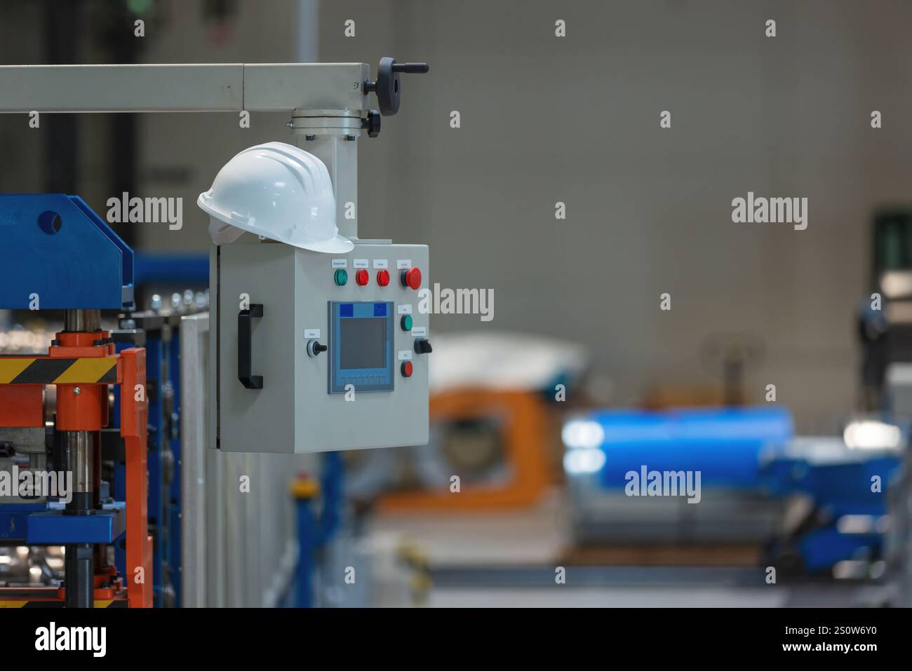Leere Industriemaschinen in den automatisierten Produktionsanlagen mit Schutzhelm. Metallverarbeitende Industrie und Technologiekonzept. Stockfoto