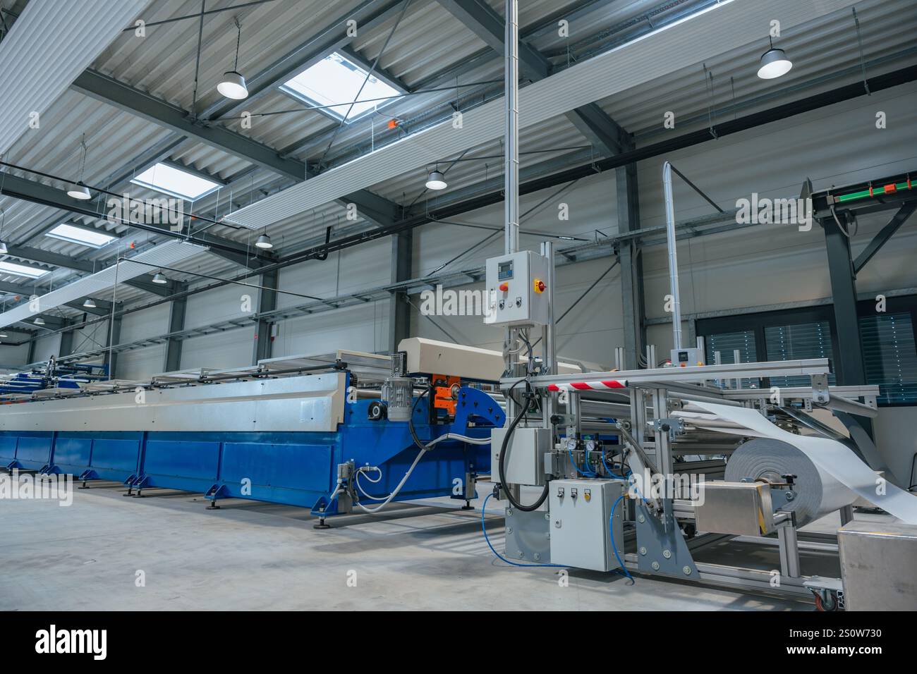Produktionslinie in einer Metallfabrik mit automatisierten Maschinen. Modernes Geschäftskonzept für Industrie und Fertigung. Stockfoto