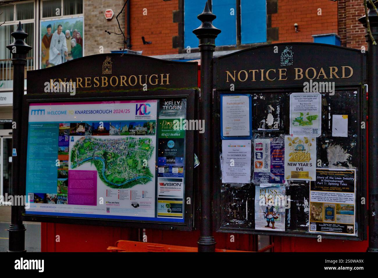 Zwei benachbarte Anzeigetafeln in Knaresborough, Großbritannien. Eine zeigt einen Stadtplan und lokale Informationen, die andere zeigt verschiedene Poster für Veranstaltungen in der Gemeinde und nein Stockfoto