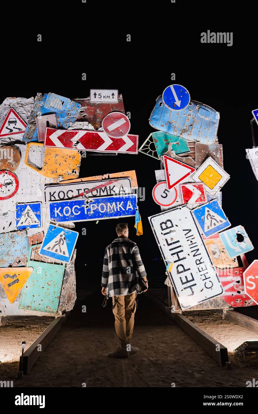 Die Person geht nachts durch das beleuchtete Straßenschild Bogenway Stockfoto