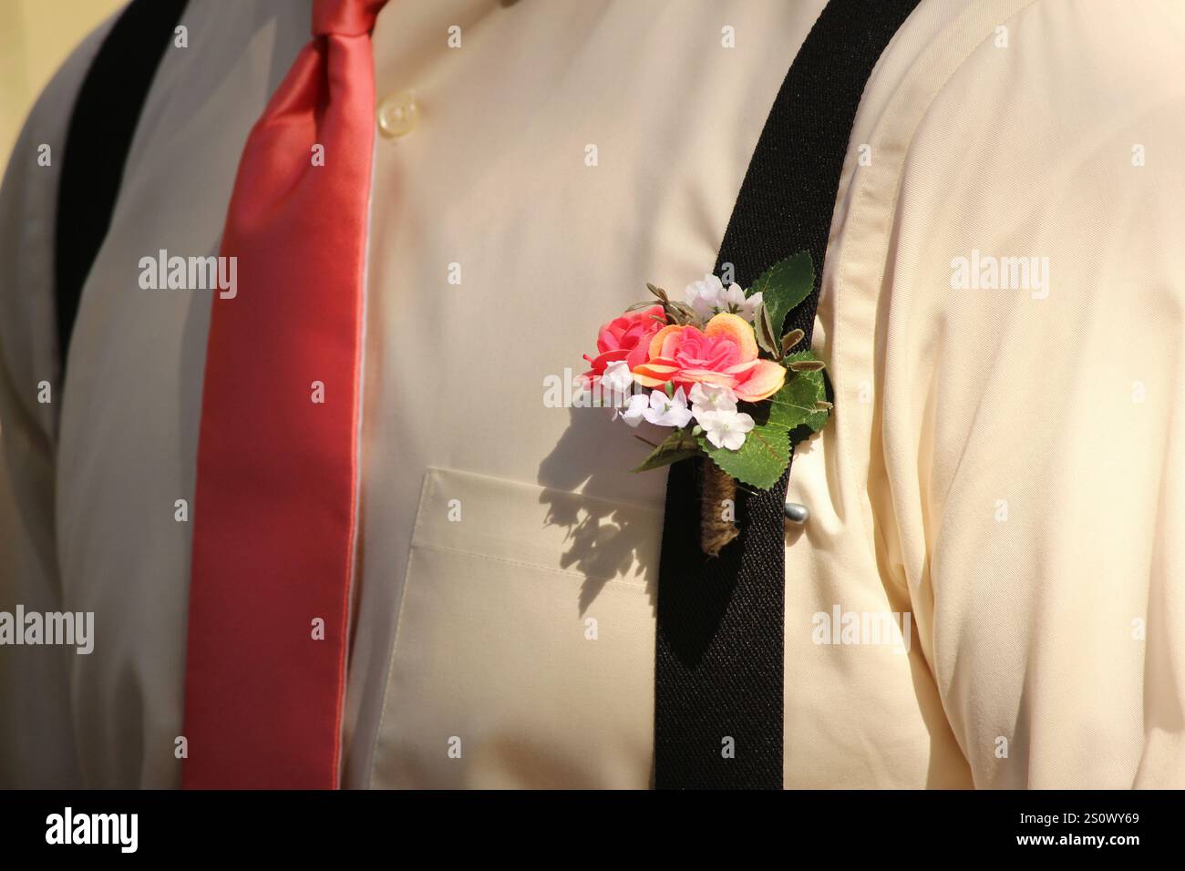 Der Trauzeuge trägt eine Boutonnière an seinen Hosenträgern während einer Hochzeit Stockfoto