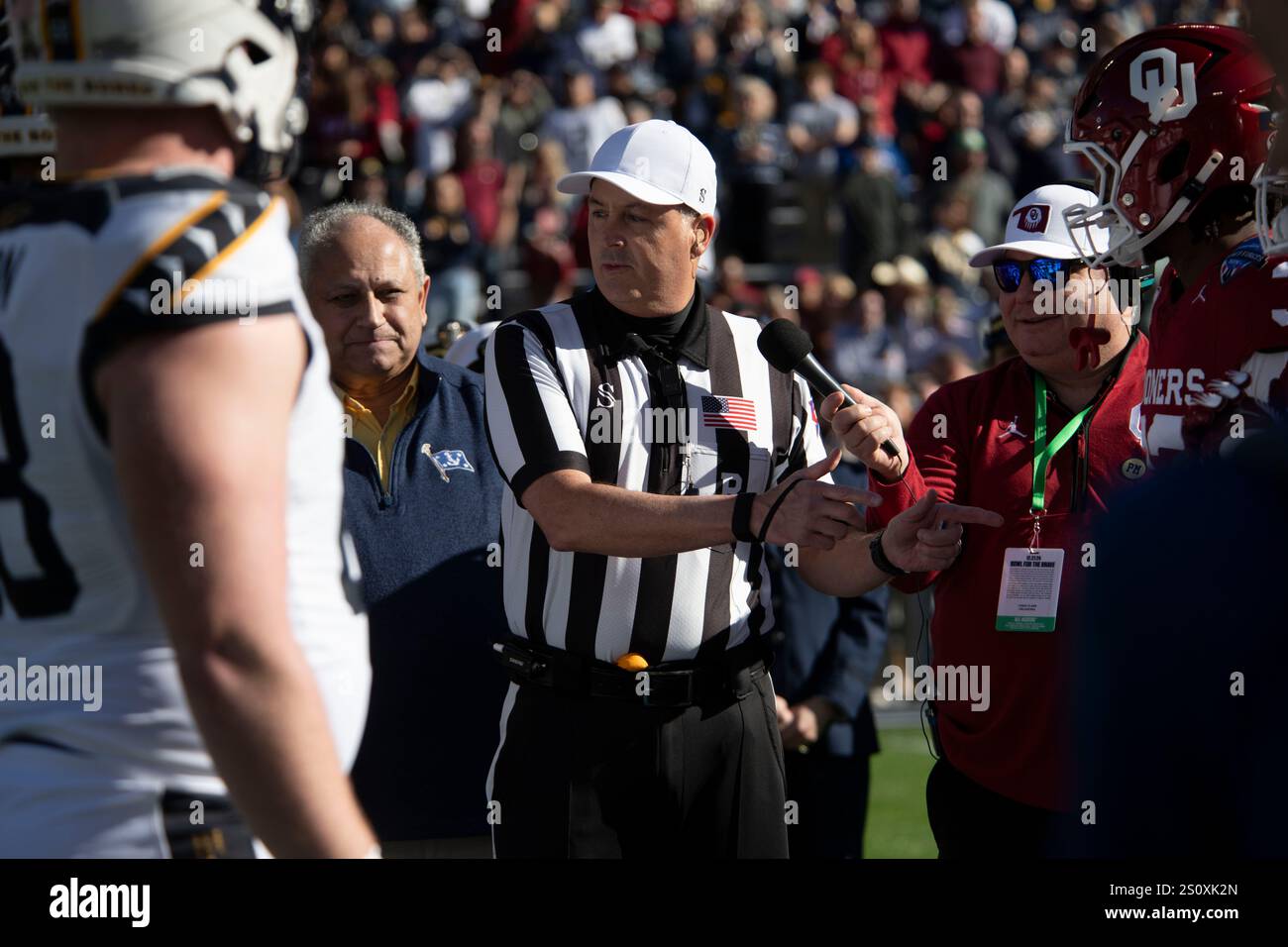 Ein Schiedsrichter unterrichtet sowohl die Midshipmen der U.S. Naval Academy als auch die University of Oklahoma Sooners über einen Münzwurf vor dem Lockheed Martin Armed Forces Bowl 2024 in Fort Worth, Texas, 27. Dezember 2024. Dies war der 22. Jährliche Armed Forces Bowl im Amon G. Carter Stadium der Texas Christian University. (Foto der U.S. Air Force von Staff Sgt. Thomas Johns) Stockfoto