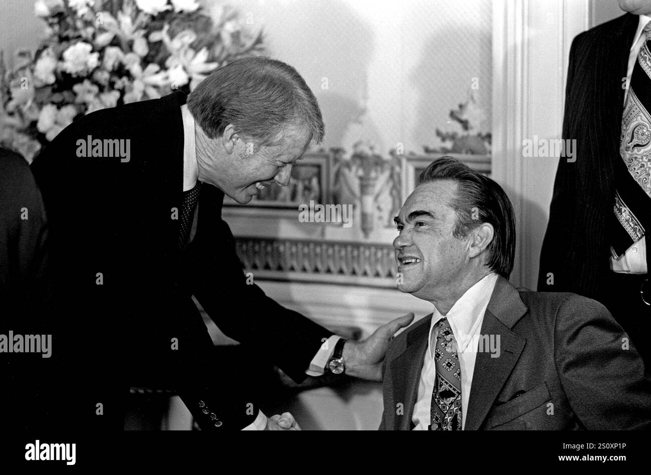 US-Präsident Jimmy Carter, Left, begrüßt Gouverneur George C. Wallace (Demokrat von Alabama) bei einem Empfang für Gouverneure und ihre Ehepartner im Blauen Zimmer des Weißen Hauses in Washington, DC, am ersten vollen Tag der Carter-Mondale-Administration am 21. Januar 1977. Kredit: Barry A. Soorenko/CNP Stockfoto