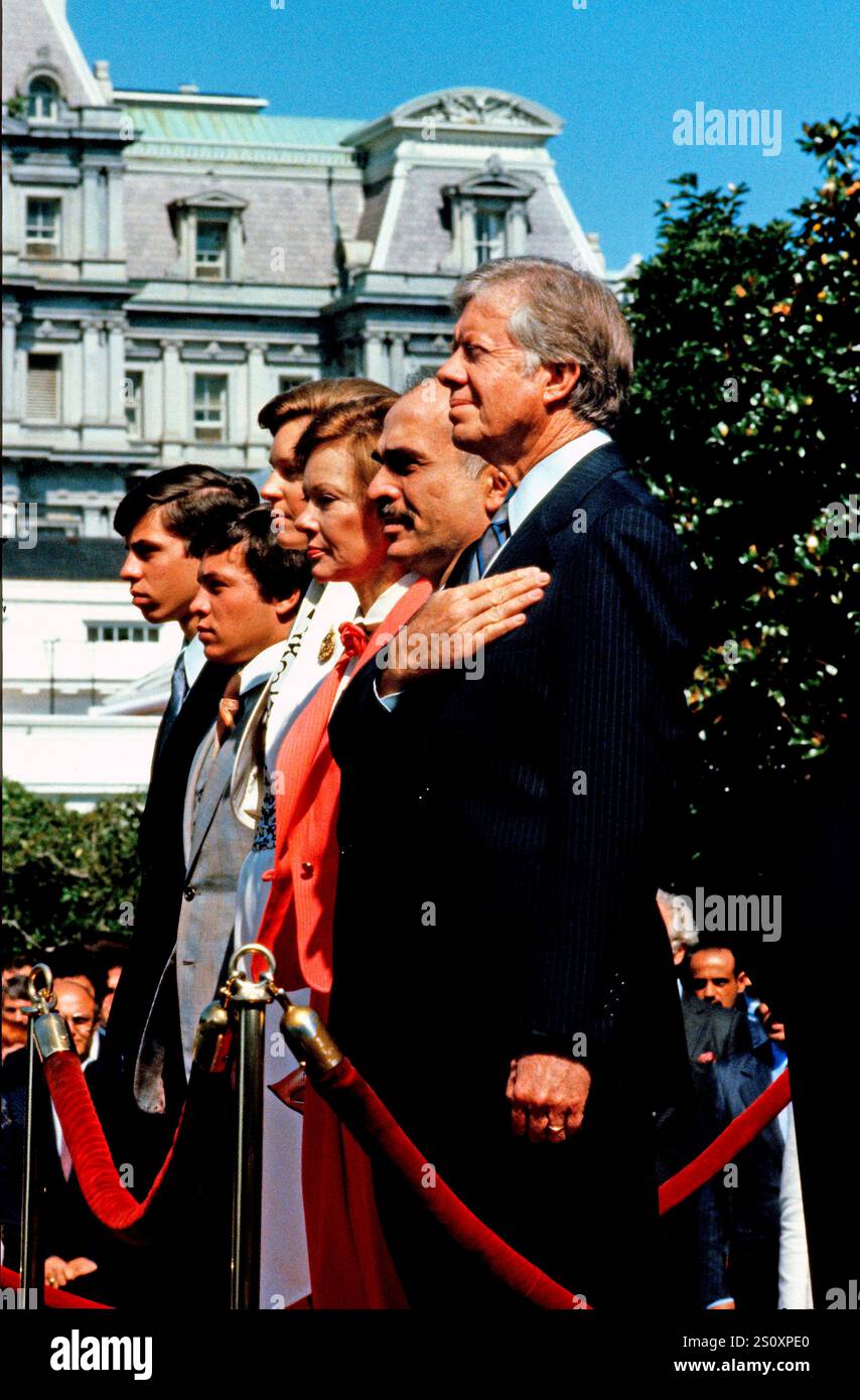US-Präsident Jimmy Carter, rechts, König Hussein I. von Jordanien, zweite rechts, und First Lady Rosalynn Carter, dritte rechts, stehen auf der Bühne, als die Nationalhymne am 17. Juni 1980 während einer Ankunftszeremonie auf dem Südrasen des Weißen Hauses in Washington, DC, aufgeführt wird. Ebenfalls abgebildet sind König Husseins Söhne Abdullah II. Bin Al-Hussein, zweite links und Prinz Faisal bin Hussein links. Quelle: Benjamin E. „Gene“ Forte/CNP Stockfoto