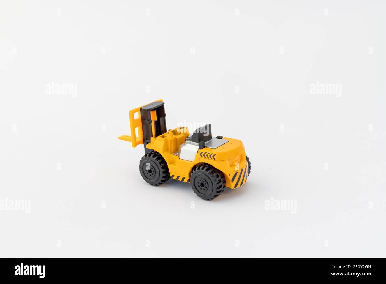 Spielzeug-Mini-Gabelstapler auf weißem isoliertem Hintergrund Stockfoto