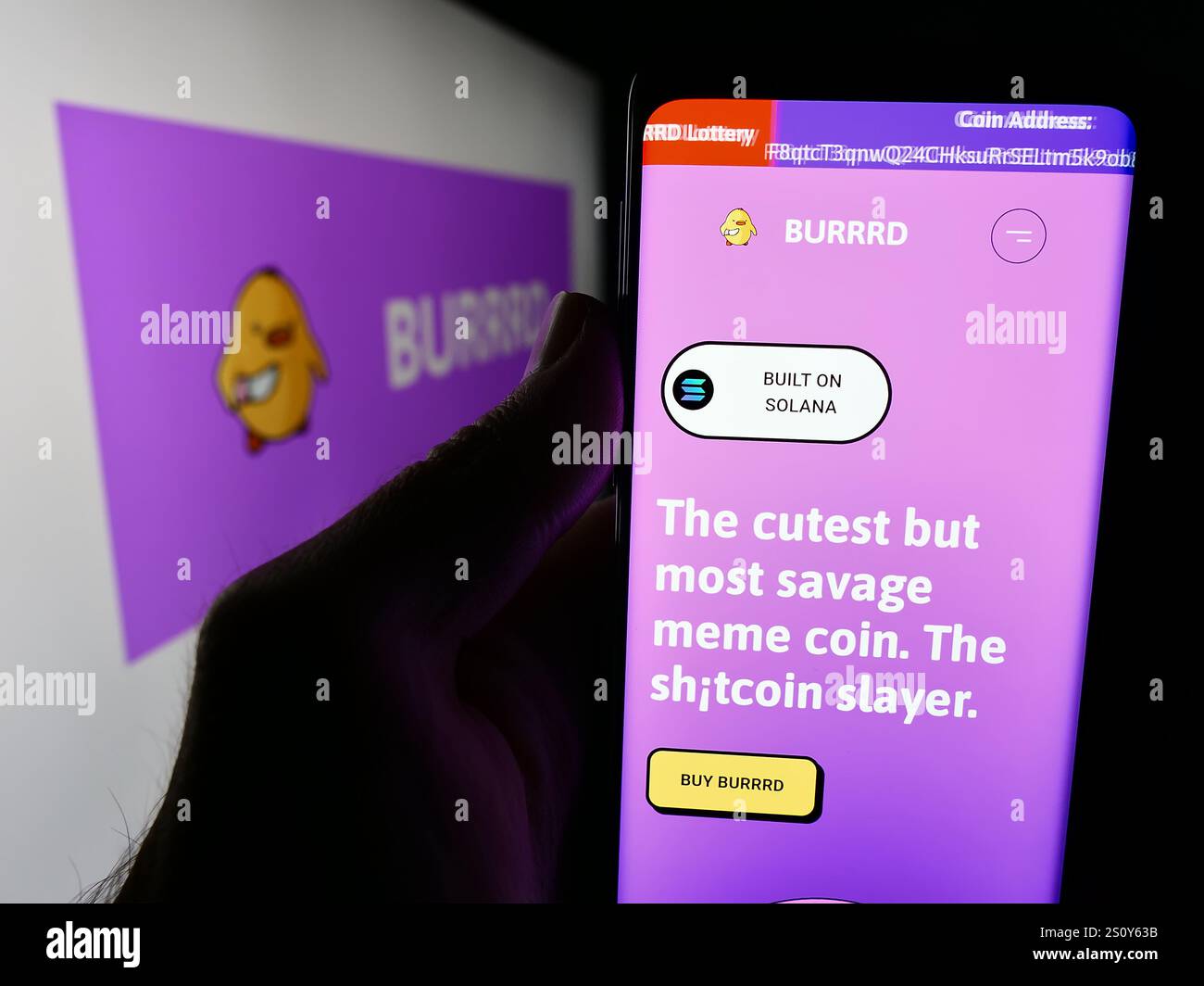 In dieser Abbildung hält eine Person ein Mobiltelefon mit der Website von MEME COIN BURRRD vor dem Logo. Stockfoto