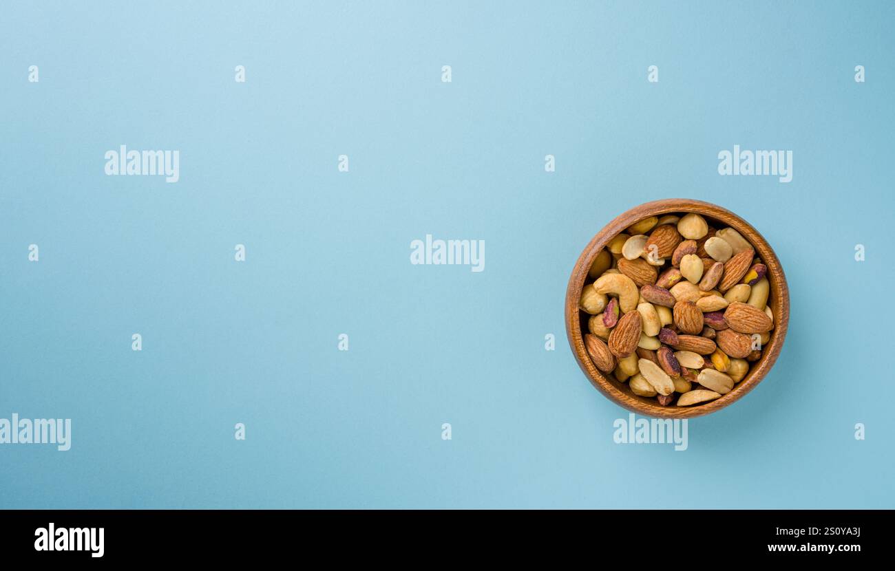 Gemischte Nüsse, bestehend aus Cashewnüssen, Haselnüssen, Mandeln und Pistazien in einer Holzschale Stockfoto