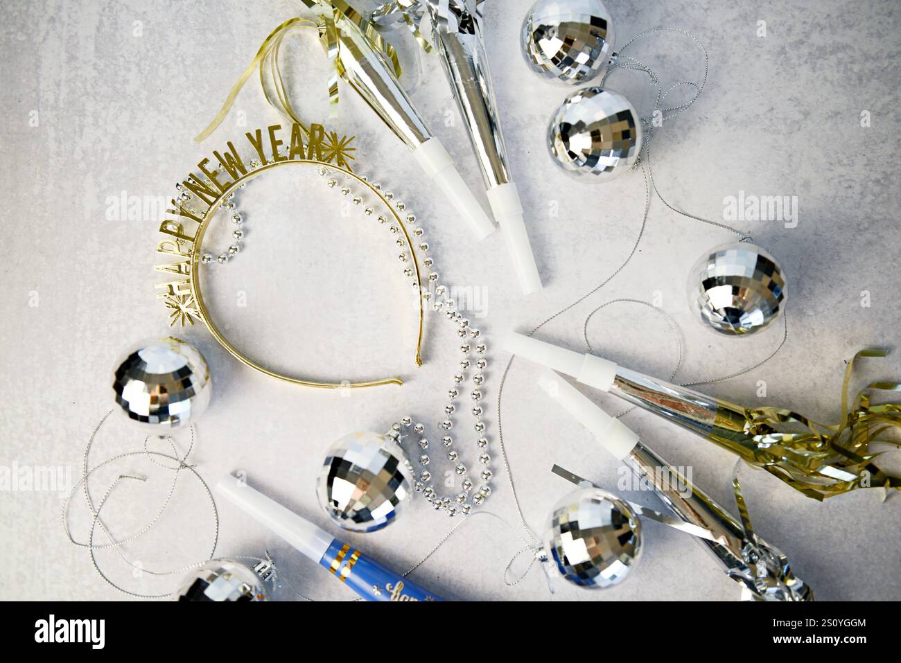 Goldenes Stirnband „Happy New Year“, Discokugeln, Partyhörner und si Stockfoto