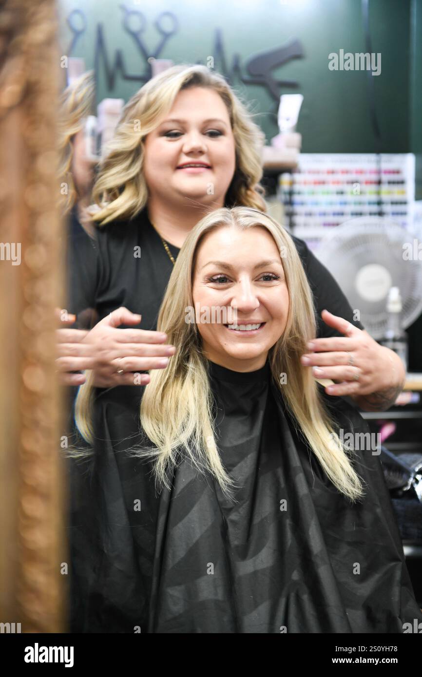 Friseur mit frisch gestyltem blondem Haar zum Lächeln Stockfoto