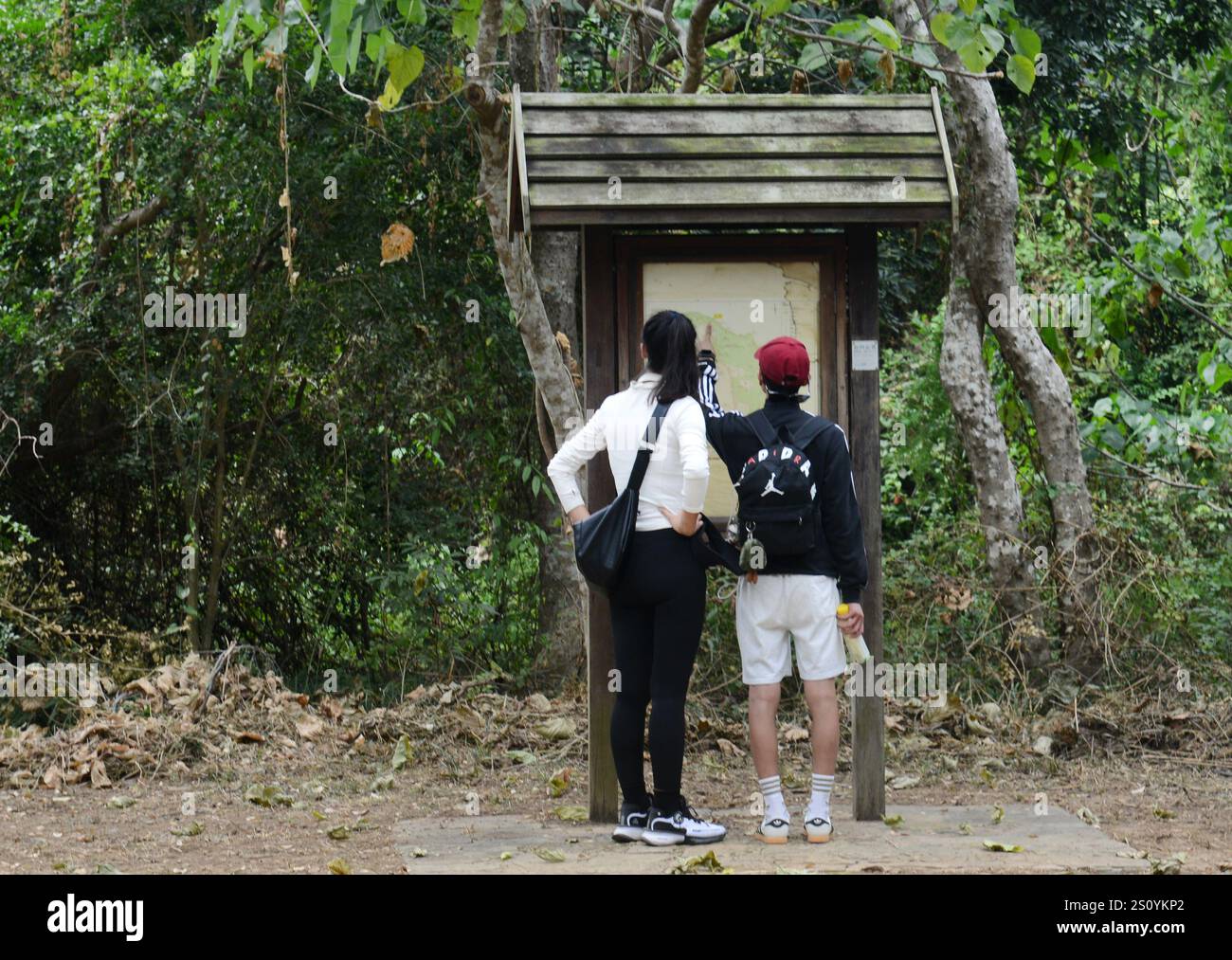 Touristen überprüfen die Karte von Tung Ping Chau entlang des Wanderweges auf der Insel. Stockfoto