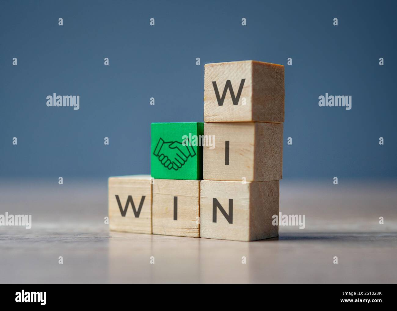 Holzblöcke mit dem Wort „WIN“ und ein grüner Block mit einem Handshake-Symbol. Konzept der Zusammenarbeit und Partnerschaft, die zum Erfolg führen. Stockfoto
