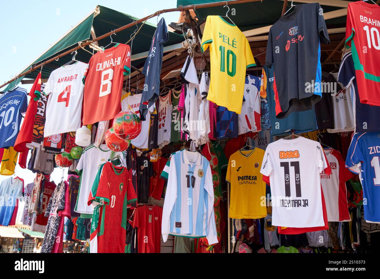 Internationale und marokkanische Fußballtrikots zum Verkauf an einem Verkaufsstand im Souk marrakesch, marokko Stockfoto