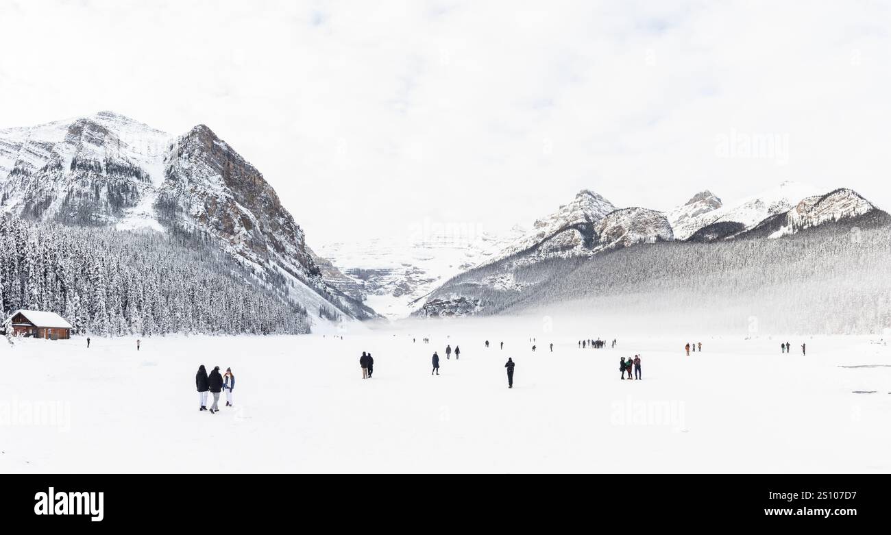 Im Banff National Park, Kanada, erwartet Besucher eine atemberaubende Landschaft des gefrorenen Lake Louise, mit schneebedeckten Bergen Stockfoto